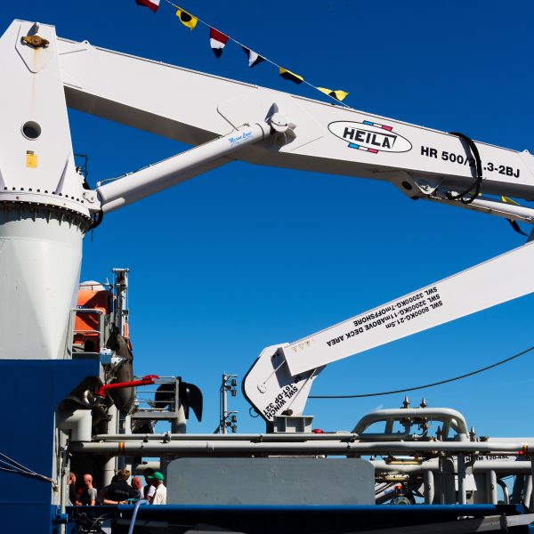 Karlskrona, Sweden - August 27, 2016: Large marine crane onboard the Swedish coast guard ship KBV 003 as seen from dockside. It is open ship day for the public and visitors are seen below the crane.