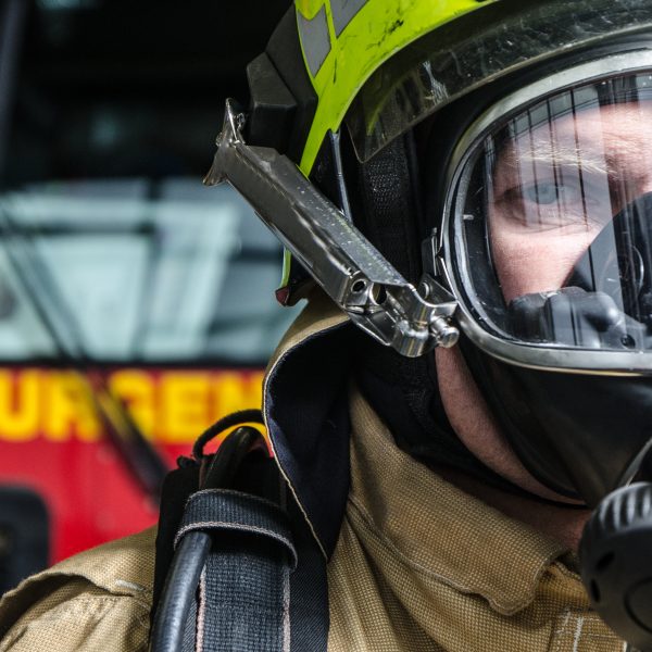 Headshot on fireman wearing full protection equipment in front of truck